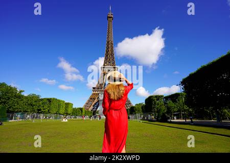 Tourisme à Paris. Vue arrière de la jeune femme regarde la Tour Eiffel depuis le champ de Mars à Paris, France. Banque D'Images