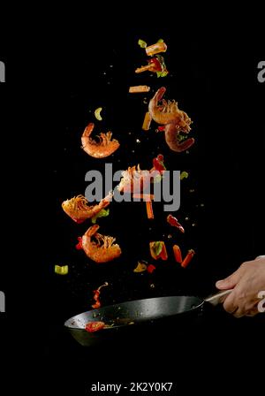 Cuisez les crevettes et légumes rôtis du chef dans une poêle à frire Banque D'Images