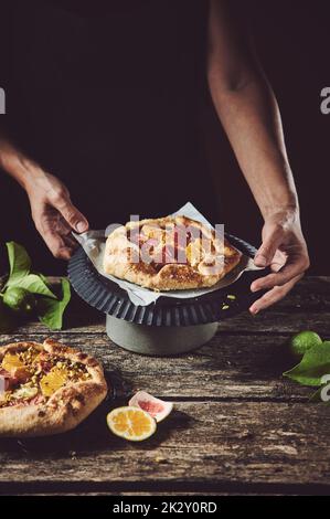 Cuisinier anonyme avec pâtisserie fruitée au four Banque D'Images