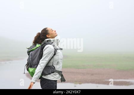 Randonneur respirant de l'air frais dans la montagne un jour brumeux Banque D'Images