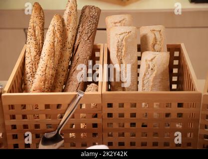 Plusieurs pains de pain, baguettes se tiennent à l'extrémité dans le panier en bois. Banque D'Images