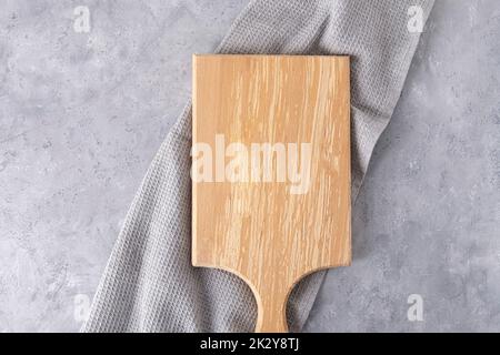 Planche à découper en bois vide sur une table de cuisine. Vue de dessus, espace de copie, maquette Banque D'Images