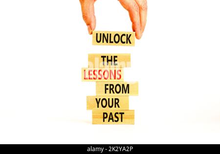 Leçons de votre ancien symbole. Concept Words déverrouillez les leçons de votre passé sur des blocs de bois. Main de Bussinesman. Magnifique fond blanc. Affaires Banque D'Images