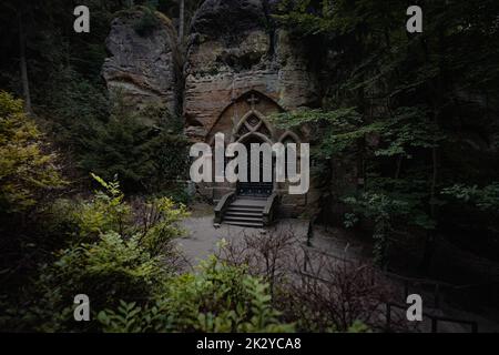 Ancienne chapelle rocheuse abandonnée cachée dans une forêt profonde dans le nord de la Bohême. Lieu plein d'ambiance créepy et hantée. Banque D'Images