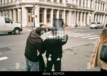 Deux hommes examinent une image radiographique dans les rues de Soho à Lower Manhattan, New York Banque D'Images