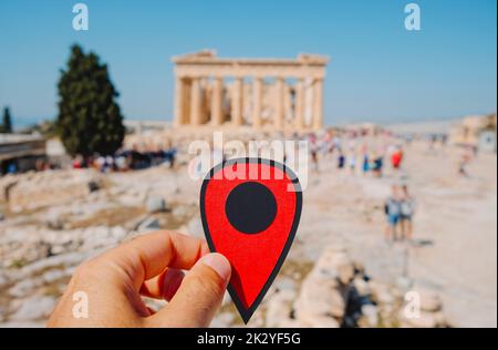 Un homme porte un marqueur rouge pointant les vestiges du célèbre Parthénon, dans l'Acropole d'Athènes, en Grèce, plein de touristes Banque D'Images