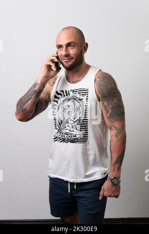 Téléphone blanc décontracté mode jeune homme vierge boxer homme, pour une chemise de jour chic et masculine. Photo de l'escalier supérieur, Banque D'Images