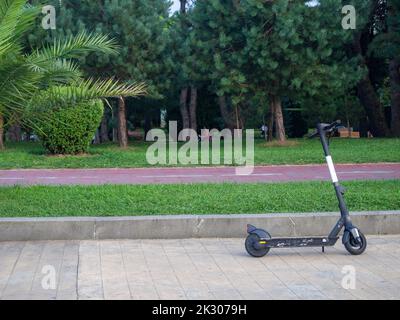 Scooters électriques sur l'allée dans le parc de la ville. Véhicule moderne. Transport à deux roues. Divertissement à la station. Banque D'Images