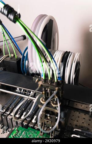 Vue verticale en intérieur d'une partie de la machine de montage SDM montrant du ruban blanc avec des pièces électroniques SMD connectées sur la carte de circuit imprimé. Photo de haute qualité Banque D'Images
