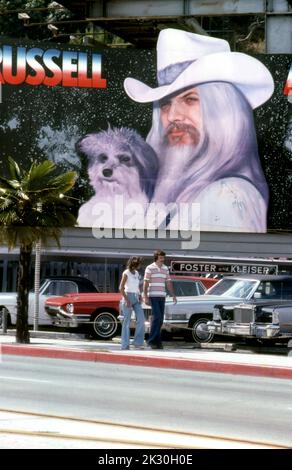Un couple passe devant un panneau d'affichage pour un disque intitulé Americana par le musicien Leon Russell sur le Sunset Strip à Los Angeles, CA,1978 Banque D'Images