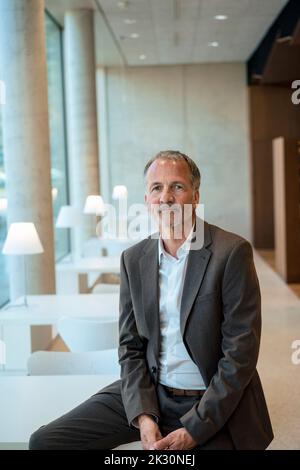 Homme d'affaires senior assis sur le bureau Banque D'Images