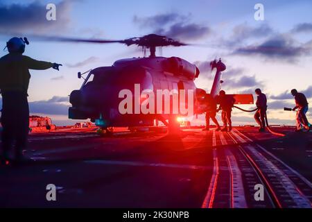 Les marins américains affectés au destroyer à missiles guidés de classe Arleigh Burke USS Shoup (DDG 86) effectuent des opérations de ravitaillement sur un hélicoptère MH-60R Sea Hawk alors qu'il est en cours dans l'océan Pacifique, le 15 septembre 2022. Shoup est en cours pour participer à un exercice Live Fire with A Purpose. (É.-U. Photo de la marine par Neil Mabini) Banque D'Images