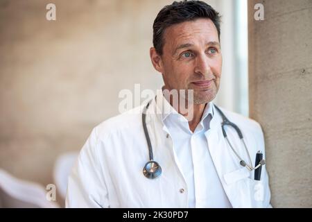 Thoughtful doctor with stethoscope around neck in hospital Banque D'Images