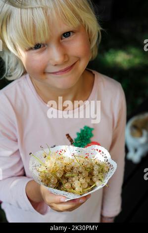 Portrait d'une petite fille tenant des raisins de Corinthe fraîchement cueillis Banque D'Images