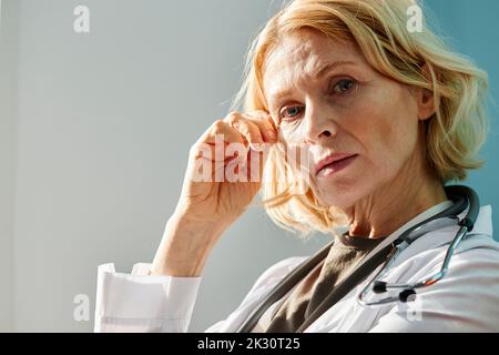 Inquiet médecin mature avec la tête dans la main à l'hôpital Banque D'Images