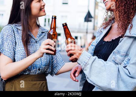 Des amis heureux debout avec des bouteilles de bière Banque D'Images