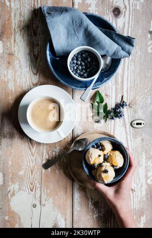 Hand of woman picking up bowl of homemade peanut ice cream Stock Photo