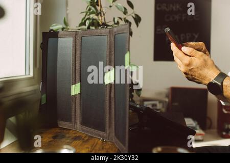 Businessman using smart phone charging tablet PC with photovoltaic solar panel Stock Photo