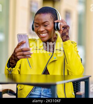 Bonne femme qui passe un appel vidéo avec un smartphone assis à table Banque D'Images