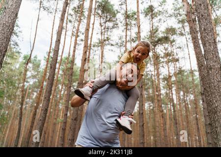 Mature man and girl having fun in forest Stock Photo