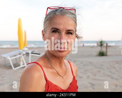 Femme âgée aux cheveux gris à la plage Banque D'Images