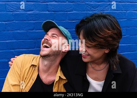 Couple gay heureux appréciant devant le mur Banque D'Images