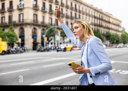 Femme d'affaires avec un tour de grêle levé à la main dans la ville Banque D'Images