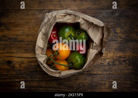 Tomates rouges, vertes et jaunes dans un sac en papier Banque D'Images