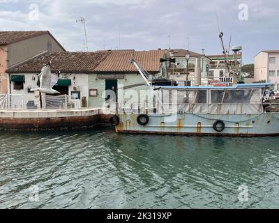 Cesenatico, Italie. Vieux bateau de pêche amarré à Porto canale, près d'un pittoresque restaurant osteria. Banque D'Images