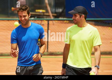 Leurs amis et leurs grands rivaux sur le terrain. Deux joueurs de tennis masculins sur le court. Banque D'Images