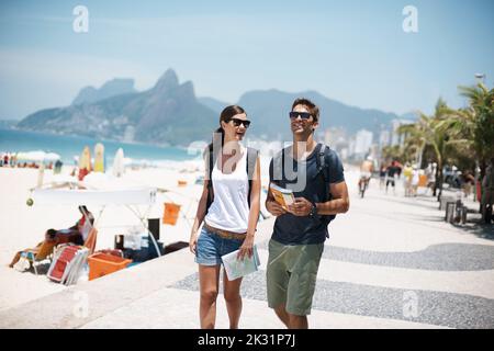 Promenade le long du paradis. Un jeune couple qui marche à côté de la plage. Banque D'Images