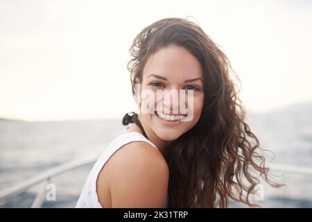 Il est temps de passer l'été. Portrait d'une jeune femme attrayante profitant d'une promenade en bateau sur le lac. Banque D'Images