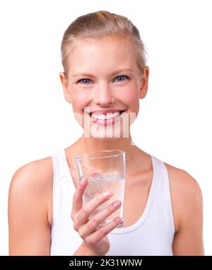 Maintenir son niveau de liquide à la hausse. Portrait d'une belle jeune femme avec un verre d'eau isolé sur blanc. Banque D'Images
