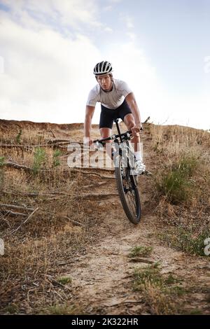 Il prend son vélo le long des sentiers. Un cycliste qui fait du plein air. Banque D'Images