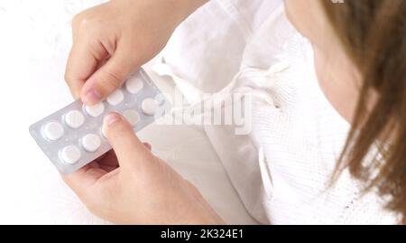 Fille malade - un adolescent presse des pilules d'un paquet. Concept médical. Banque D'Images