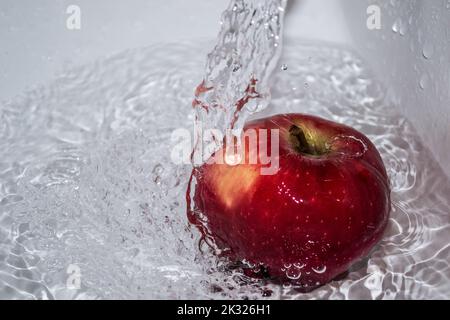 Pomme couverte d'eau. Pomme recouverte d'eau dans un bol en métal. Banque D'Images