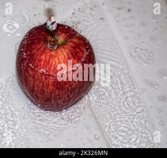 Pomme couverte d'eau. Pomme recouverte d'eau dans un bol en métal. Banque D'Images