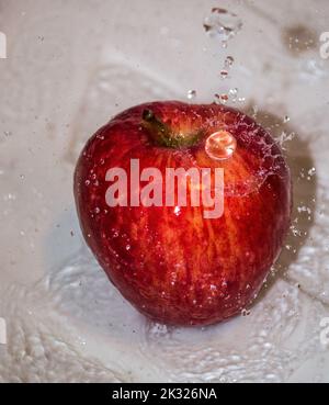 Pomme couverte d'eau. Pomme recouverte d'eau dans un bol en métal. Banque D'Images