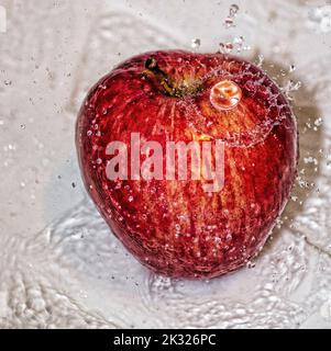 Pomme couverte d'eau. Pomme recouverte d'eau dans un bol en métal. Banque D'Images