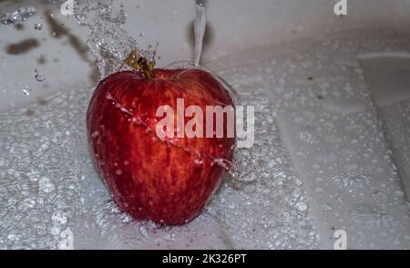 Pomme couverte d'eau. Pomme recouverte d'eau dans un bol en métal. Banque D'Images