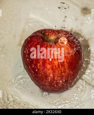 Pomme couverte d'eau. Pomme recouverte d'eau dans un bol en métal. Banque D'Images