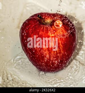 Pomme couverte d'eau. Pomme recouverte d'eau dans un bol en métal. Banque D'Images