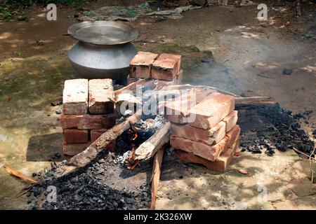 La cuisine biryani dans un village partie sur un four temporaire en brique. Cuisine extérieure pour beaucoup de personnes dans une grande poêle en aluminium au feu de bois. Banque D'Images