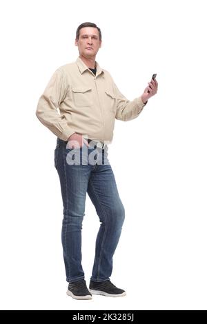 homme senior décontracté travaillant quelque chose sur son téléphone tout en tenant une main dans sa poche. Banque D'Images