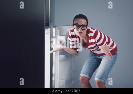 Le frigo est vide et la femme a été déçue de se hausser Banque D'Images