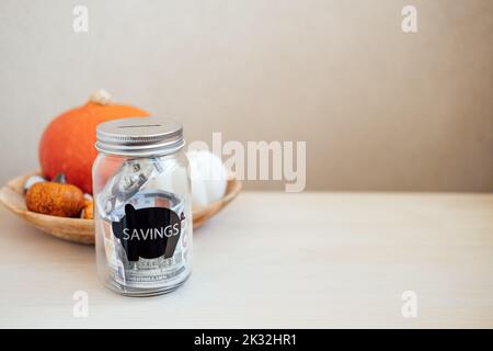 Économisez de l'argent idées pour le jour de Thanksgiving, économisez, Thanksgiving sur le budget. Pot de maçon en verre avec banque de piggy en argent sur la décoration de citrouille de Thanksgiving Banque D'Images