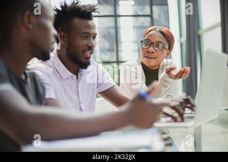 Une équipe d'affaires afro-américaine réussie qui parle de stratégie au bureau Banque D'Images