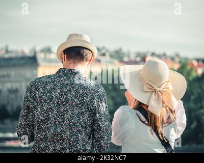 Vue arrière avec un jeune couple méconnaissable portant des chapeaux de paille et profitant de la vue de Prague d'un point de vue Banque D'Images