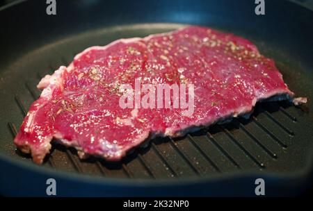 L'entrecote de bœuf sanglant est frit dans une poêle. Banque D'Images
