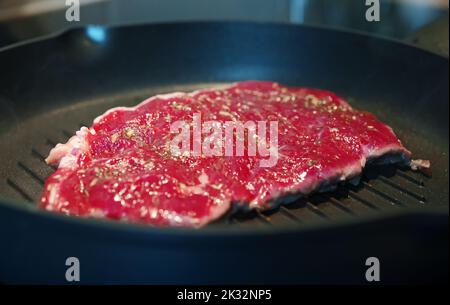 L'entrecote de bœuf sanglant est frit dans une poêle. Banque D'Images